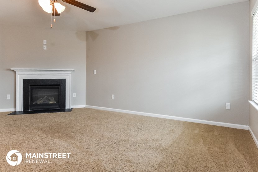 the living room of an empty house with a fireplace