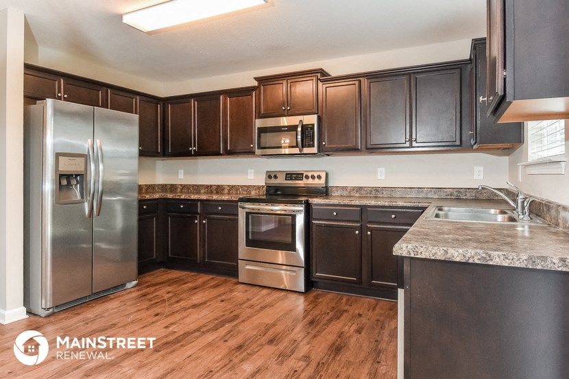 a kitchen with dark wood cabinets and stainless steel appliances
