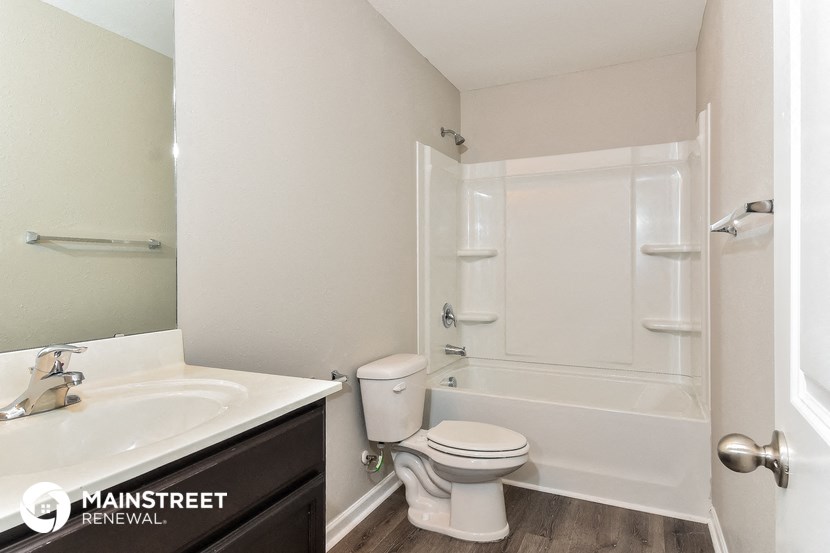 a bathroom with a toilet sink and tub and a mirror