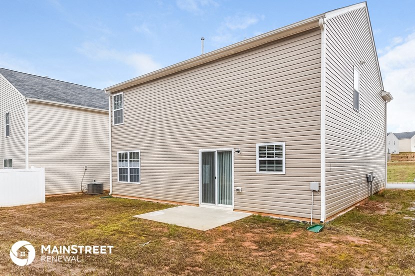a large white house with a yard and a backdoor