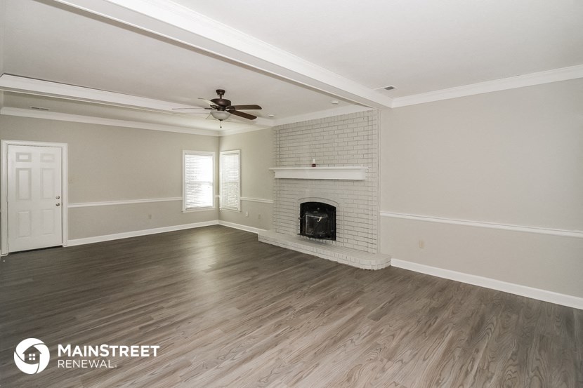 the living room of an empty house with a fireplace