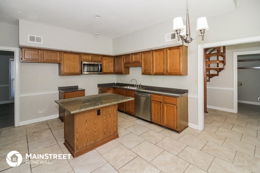 a kitchen with wooden cabinets and stainless steel appliances
