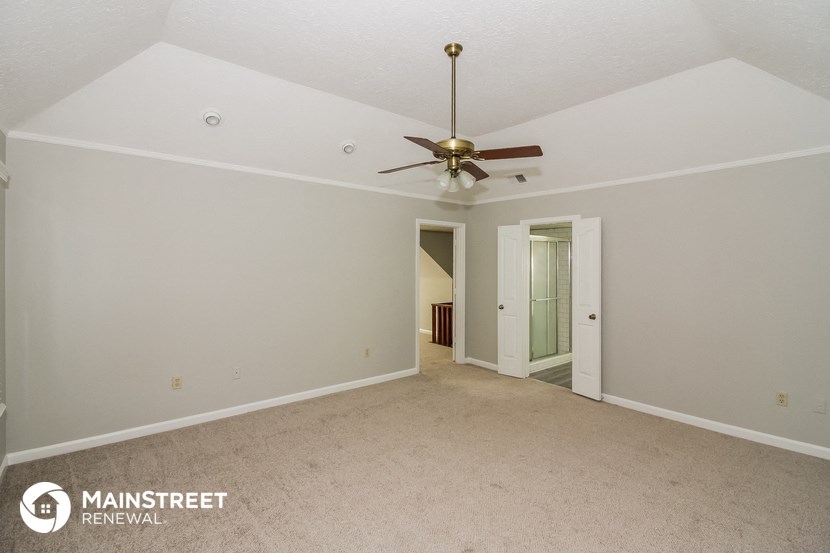 the living room of an empty house with a ceiling fan
