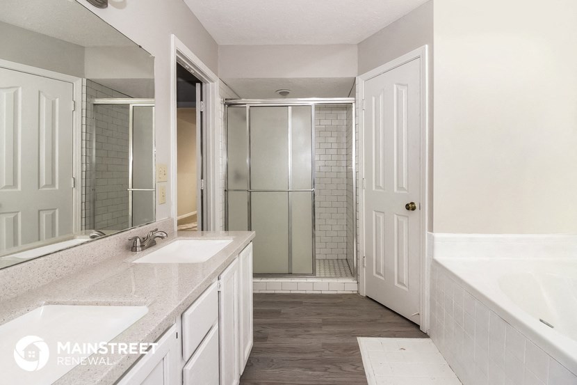 a white bathroom with two sinks and a shower