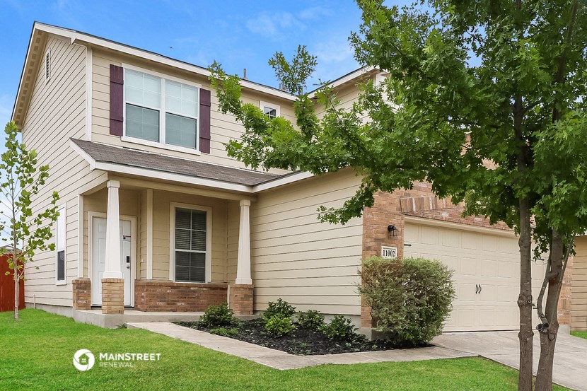 a tan house with a tree in front of it