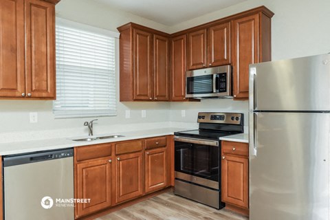 a kitchen with wooden cabinets and stainless steel appliances