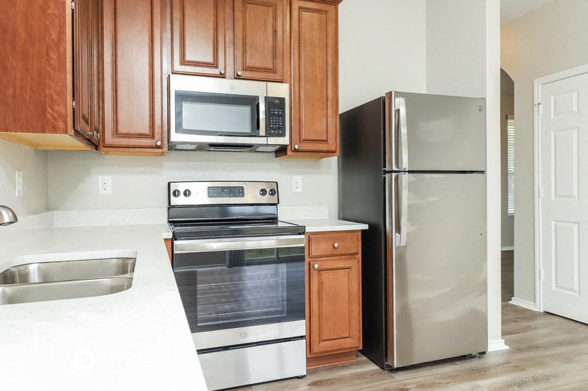a kitchen with stainless steel appliances and wooden cabinets