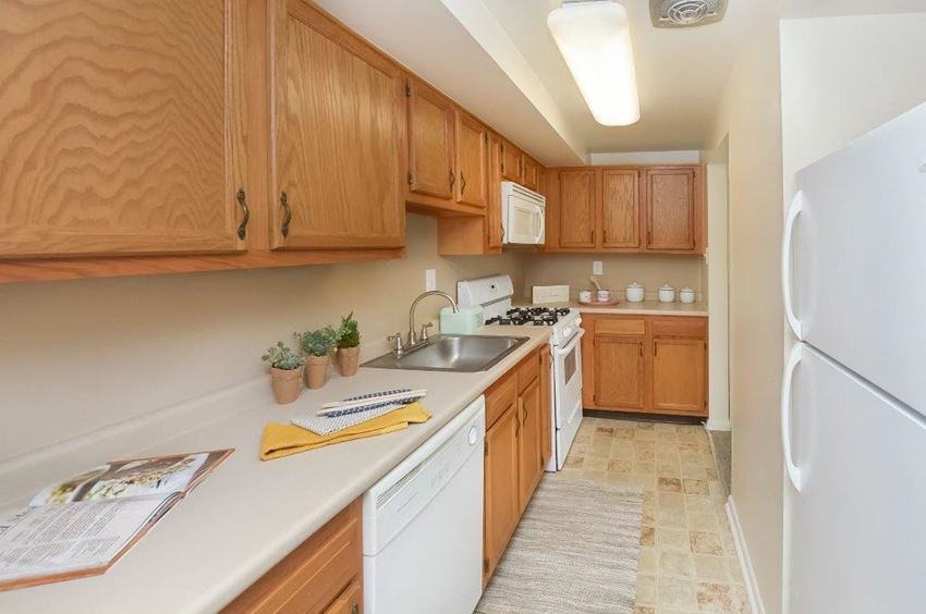 a kitchen with white appliances and wooden cabinets