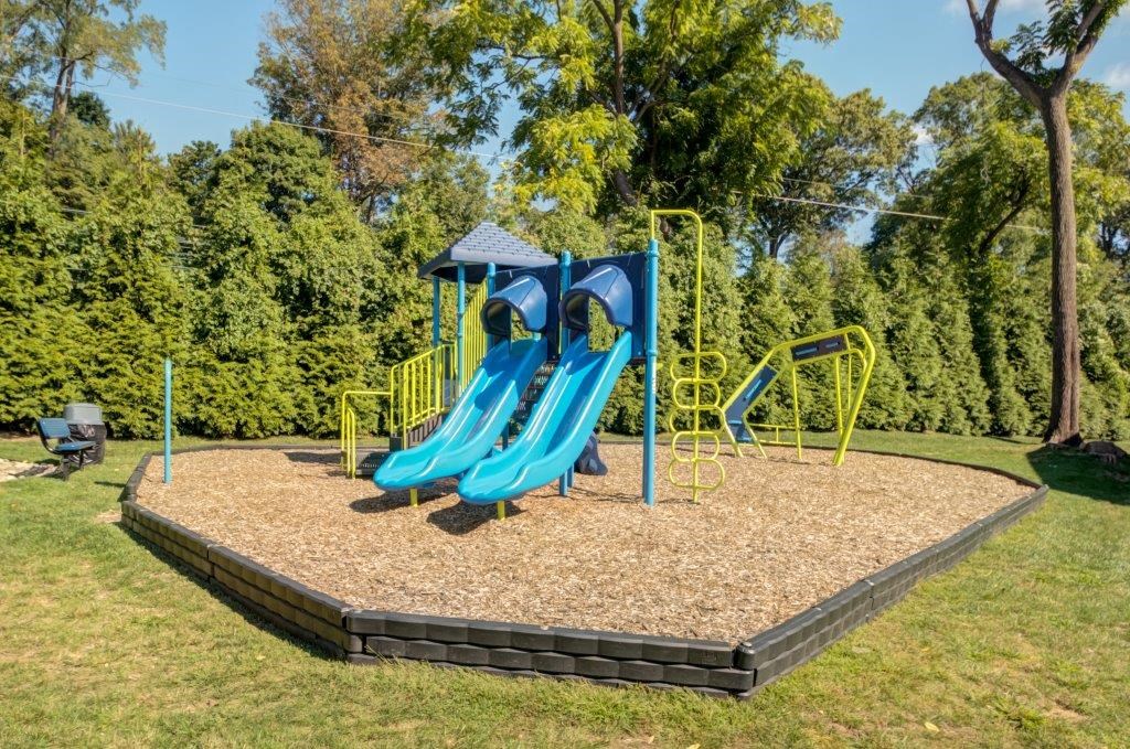 a playground with a blue slide in a park