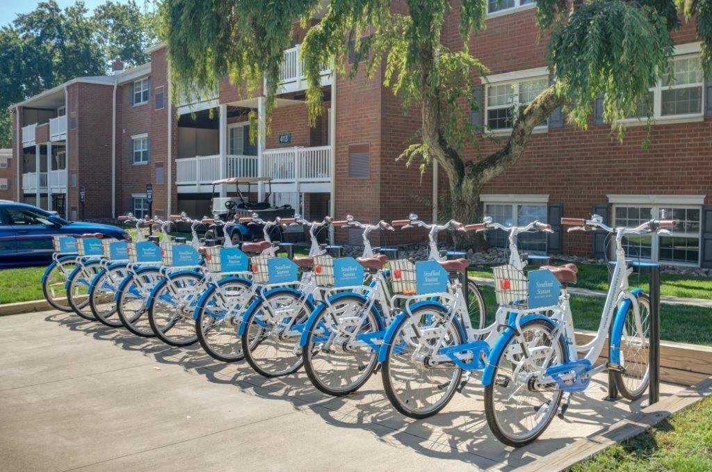 a row of blue bikes parked in front of a building
