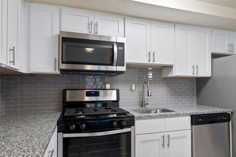a kitchen with white cabinets and a stove and a microwave