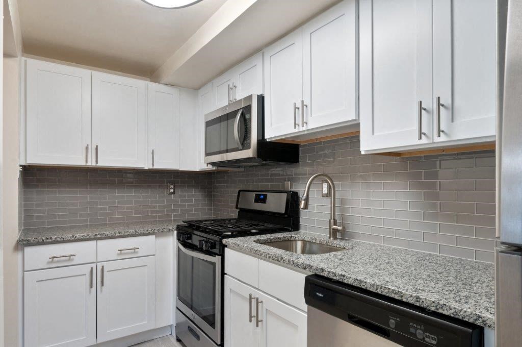 a kitchen with white cabinets and a sink and a microwave