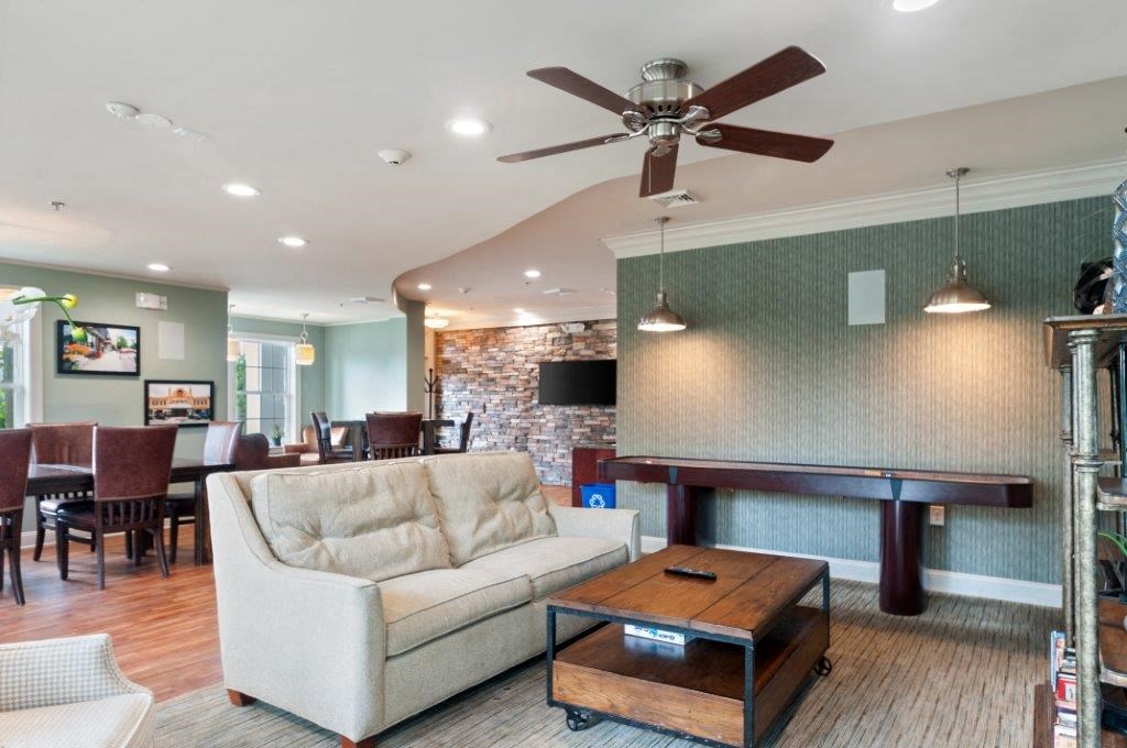 a living room with a couch a table and a ceiling fan