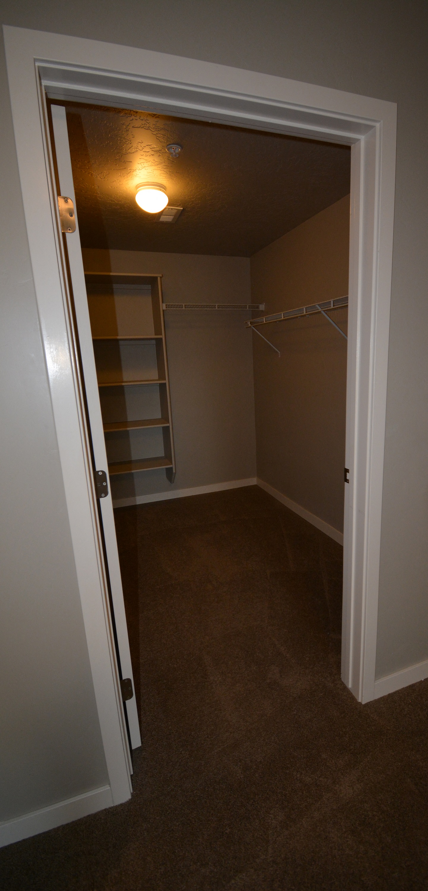 Image of walk in closet with hanger racks and shelves