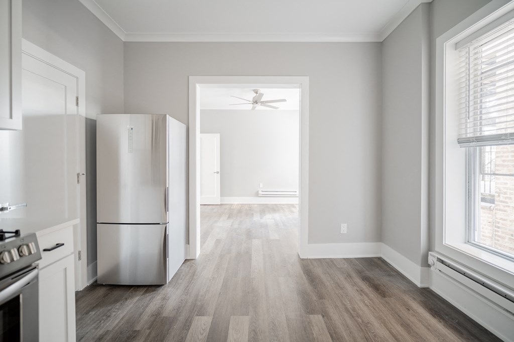 an empty kitchen and living room with a refrigerator