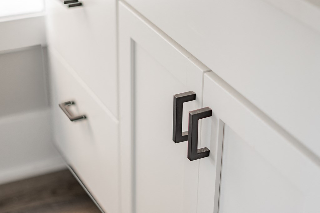 a kitchen cabinet with black handles on it