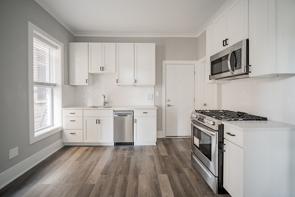a kitchen with white cabinets and a stove and a microwave