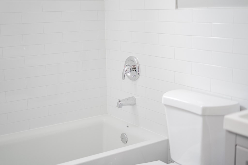 a white bathroom with a tub and a toilet