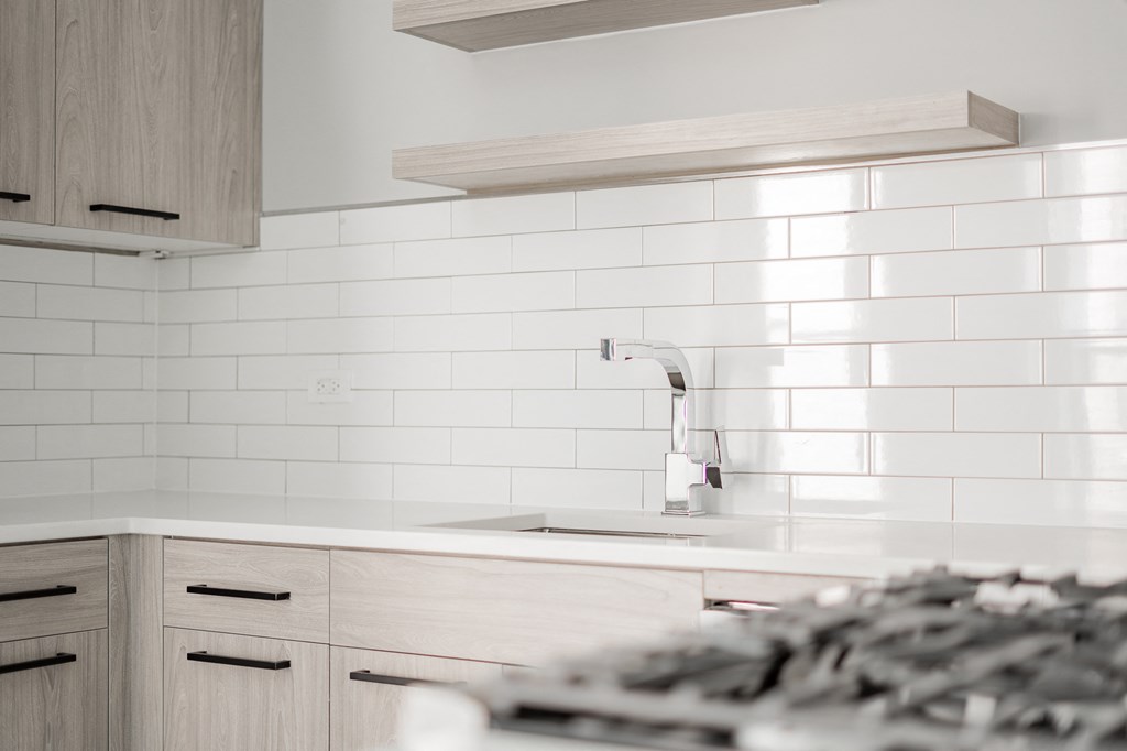 a white kitchen with wooden cabinets and a sink