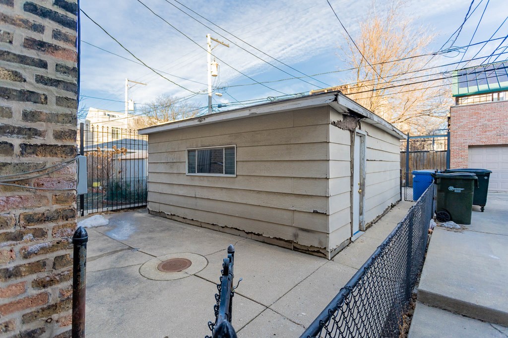 the back of a small house with a yard and a fence