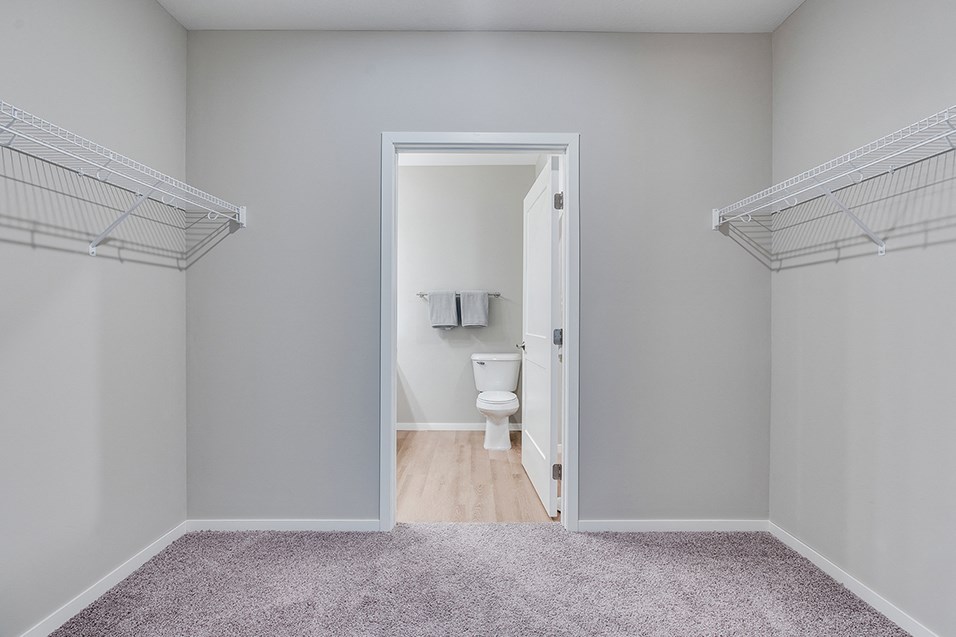 a bedroom with a door to a bathroom with a toilet