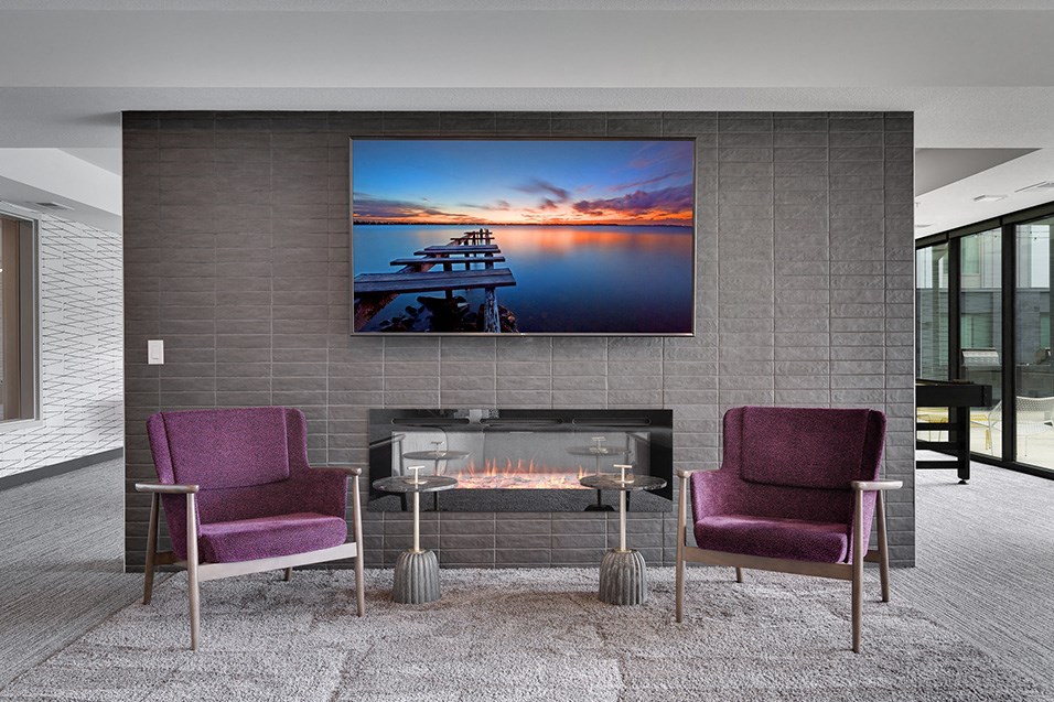 a living room with purple chairs and a fireplace