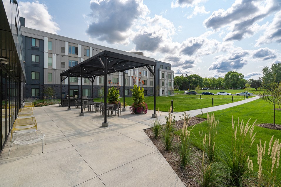 a patio with tables and chairs in front of a building