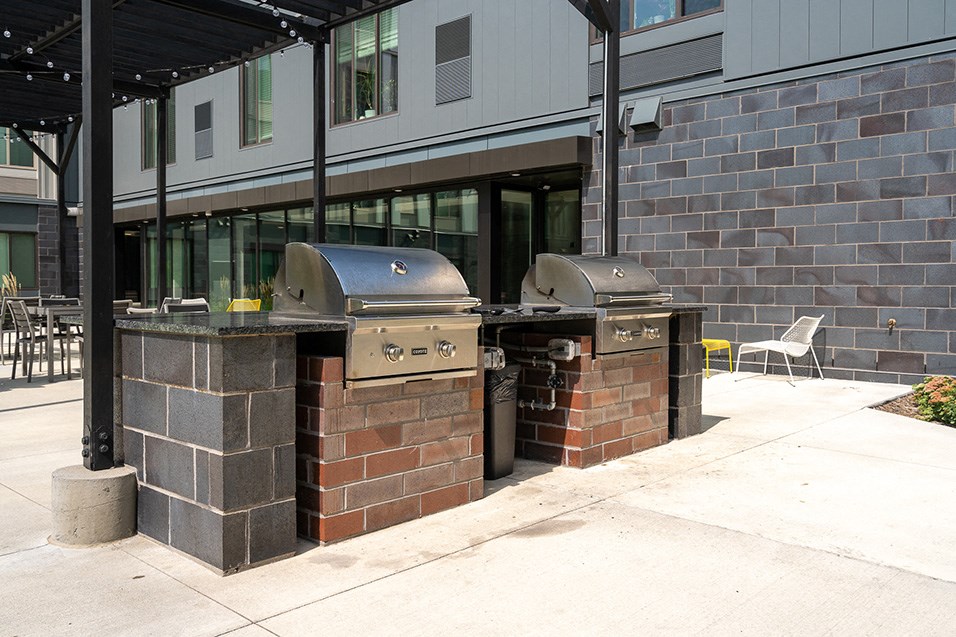 two bbq pits in front of a building