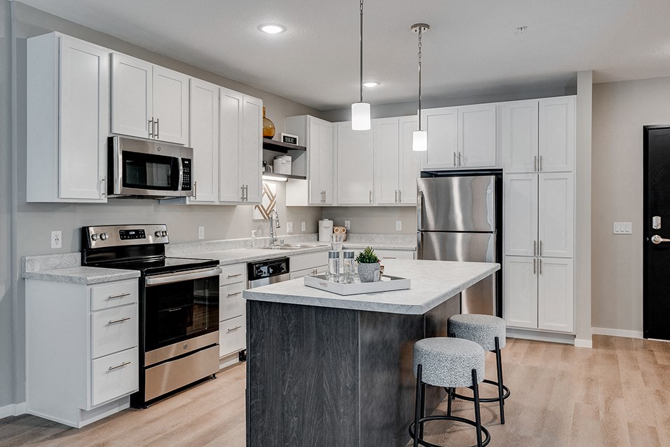 a kitchen with white cabinets and stainless steel appliances