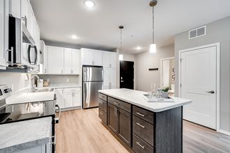 an expansive kitchen with white cabinets and stainless steel appliances