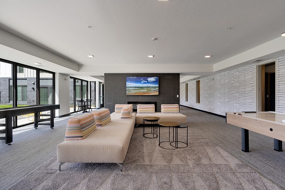 a large living room with a couch and a table with chairs