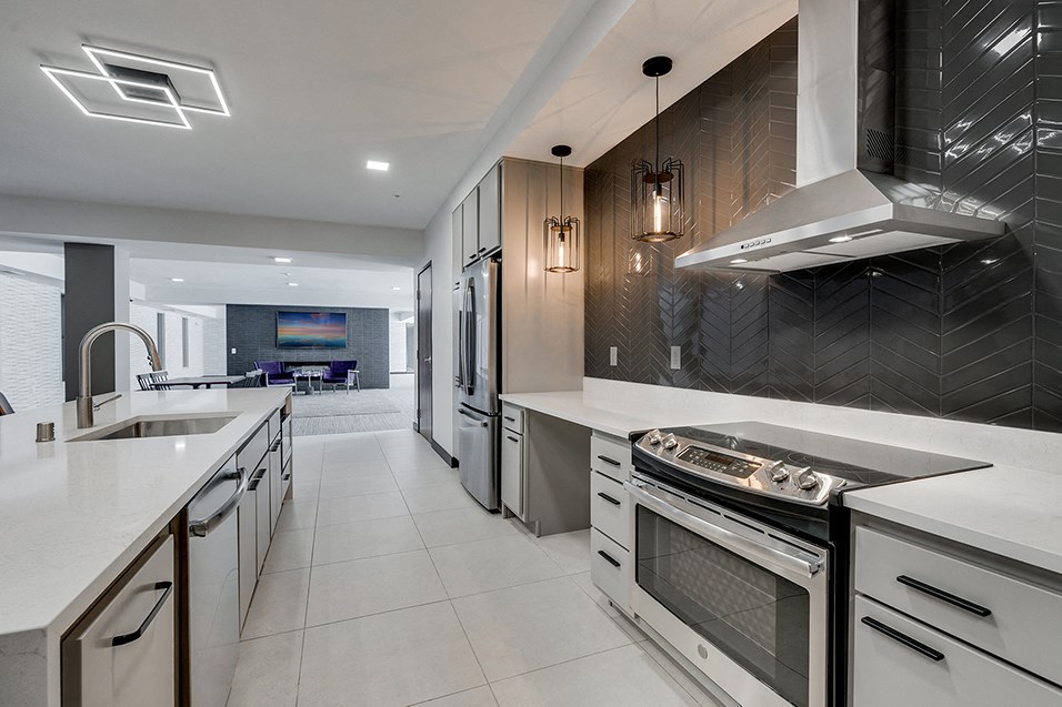 a large kitchen with white counter tops and stainless steel appliances