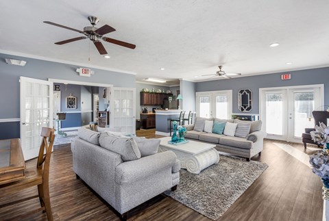 A living room with a grey couch and a wooden chair.
