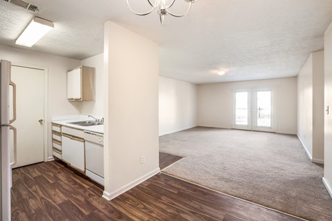 A kitchen with white cabinets and a refrigerator is visible.