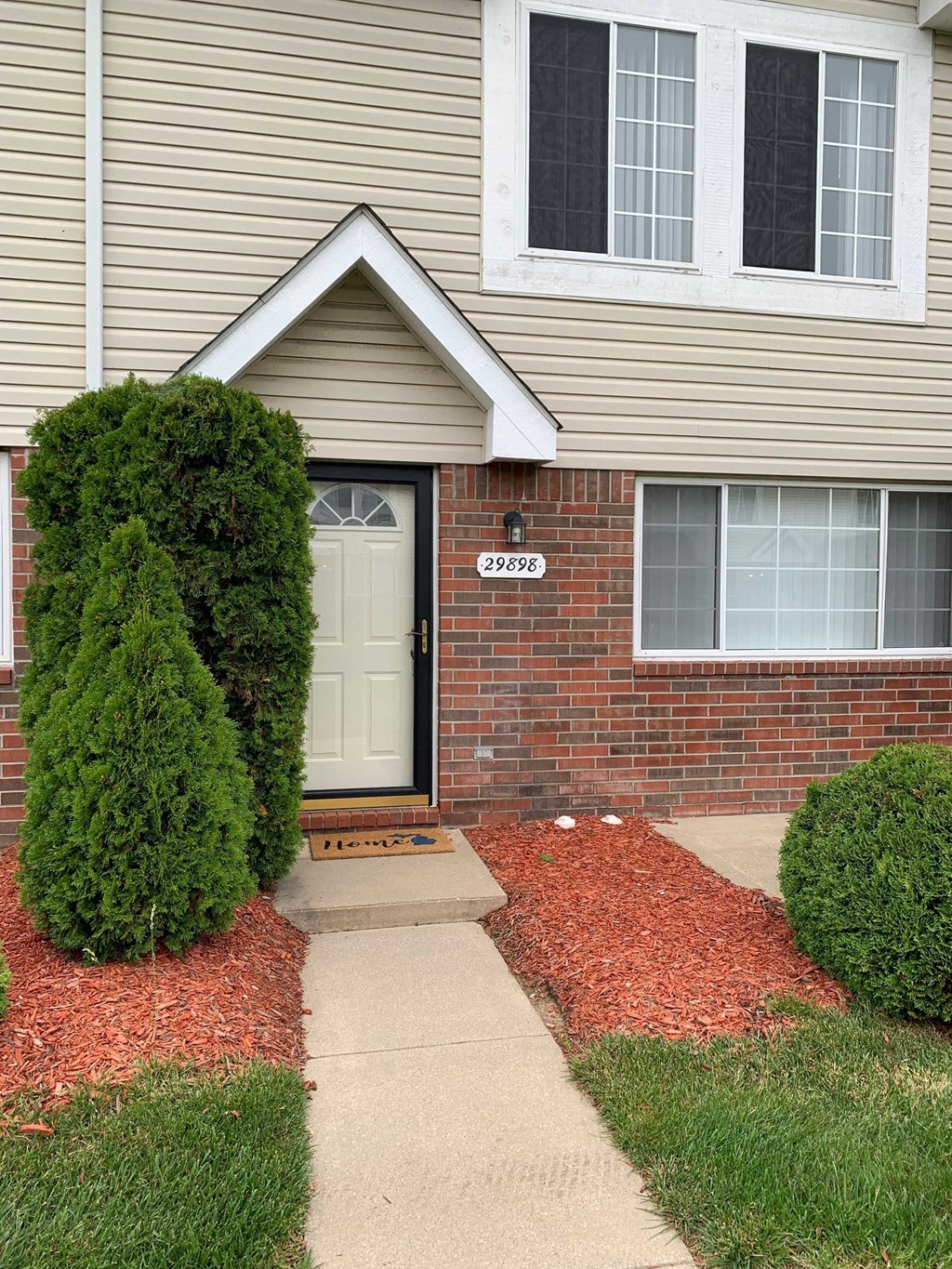 a house with a white door and a sidewalk in front of it