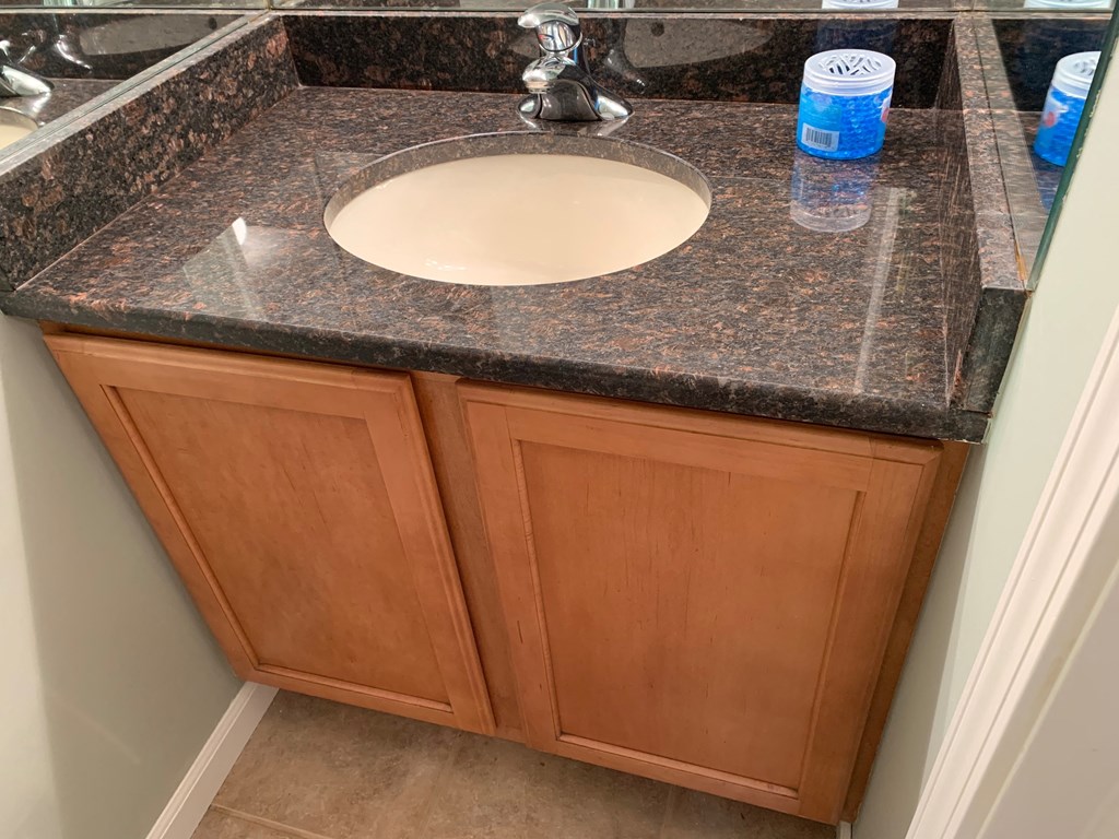 a bathroom with a sink and wooden cabinets