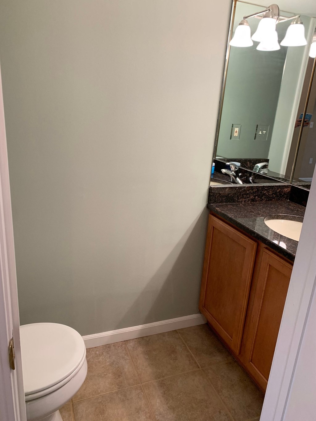 a bathroom with a toilet and a sink and a mirror