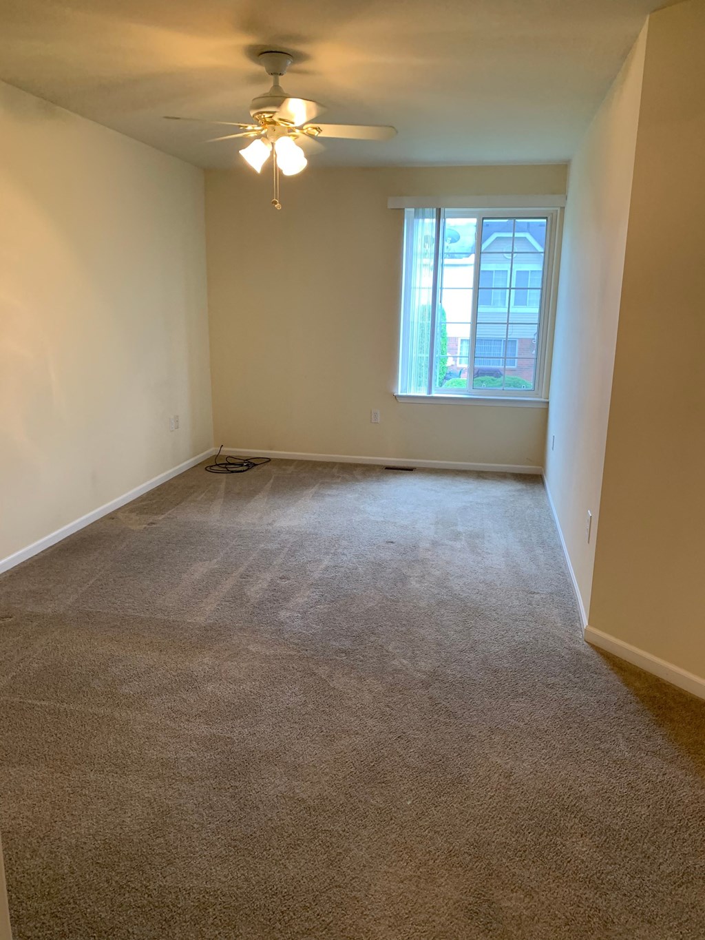 an empty room with a ceiling fan and a window