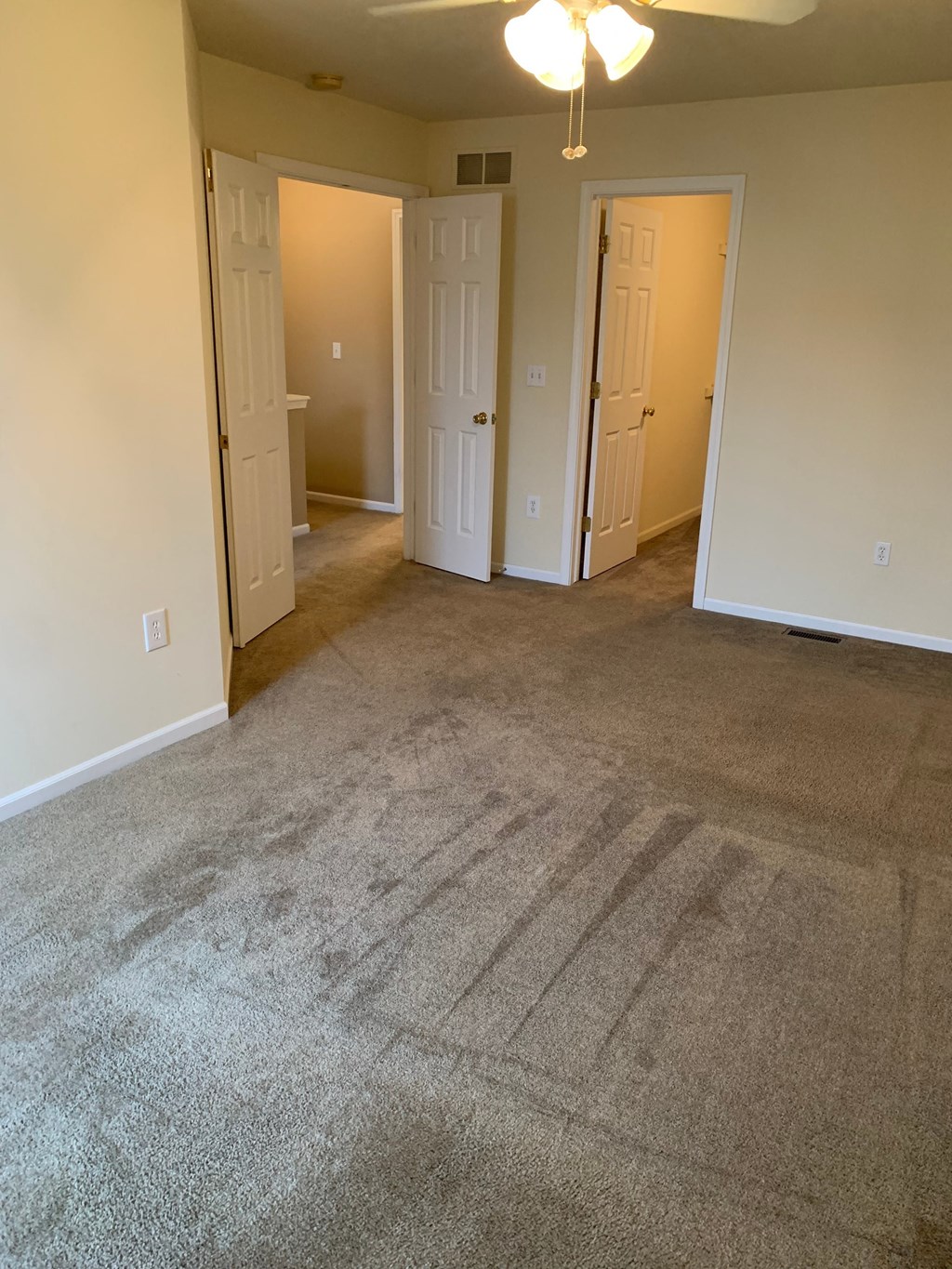 an empty living room with carpeting and white walls