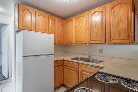 a kitchen with wooden cabinets and a white refrigerator and sink