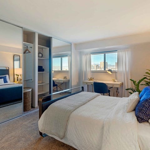 a bedroom with a bed and a closet at The Rays at Vegas Towers Apartments, Las Vegas, NV 89119