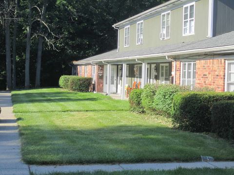 a house with a lawn and a sidewalk in front of it