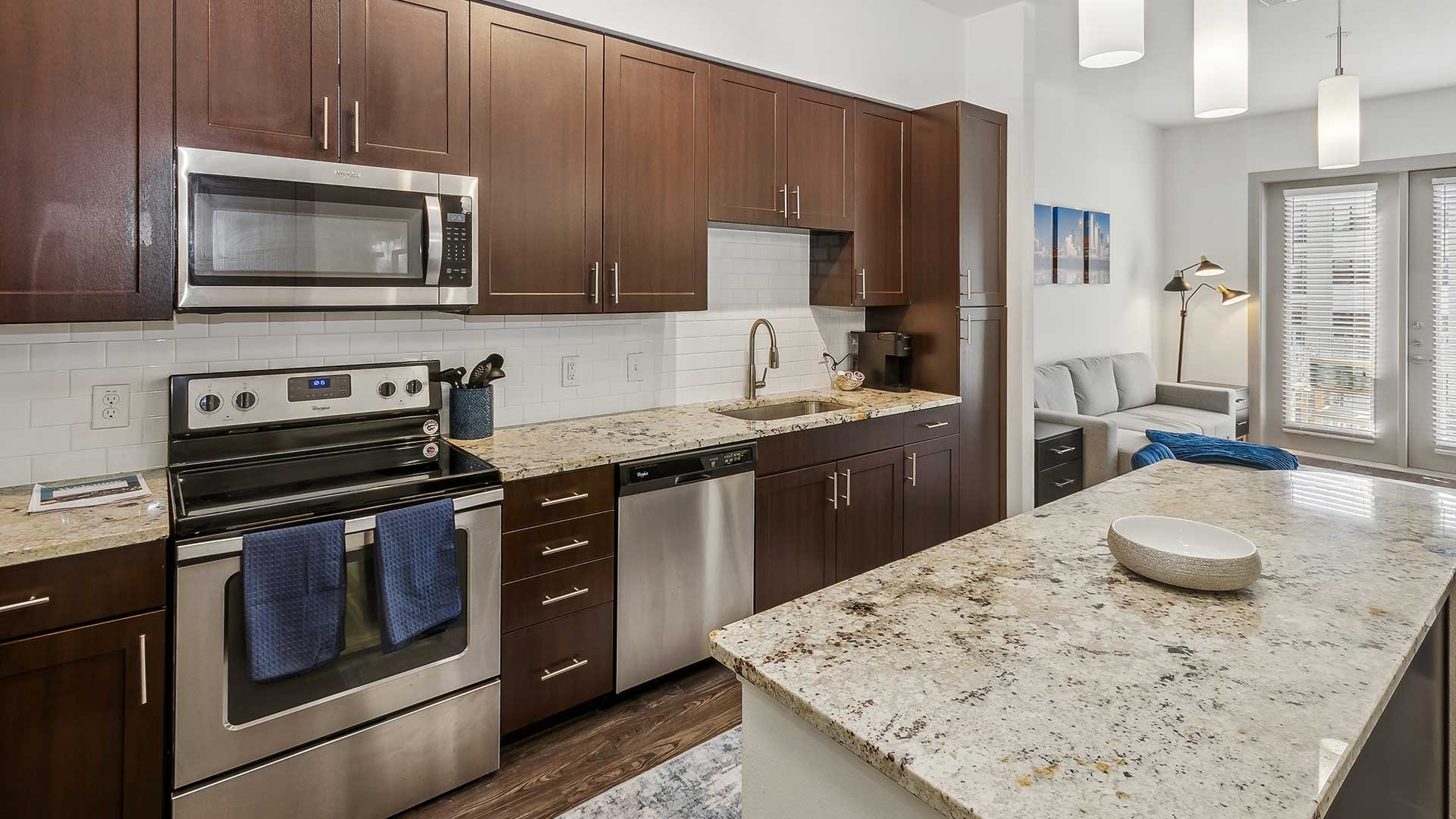 A kitchen with brown cabinets and a granite countertop.