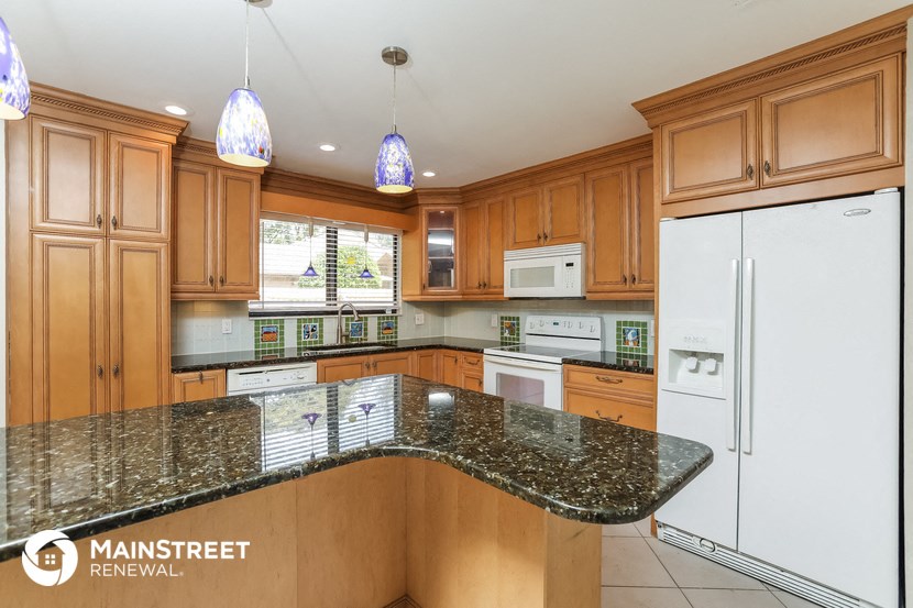 a kitchen with granite counter tops and wooden cabinets