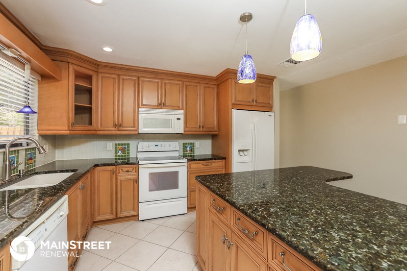 a kitchen with granite counter tops and wooden cabinets