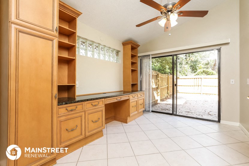 a kitchen with wooden cabinets and a sliding glass door to the patio