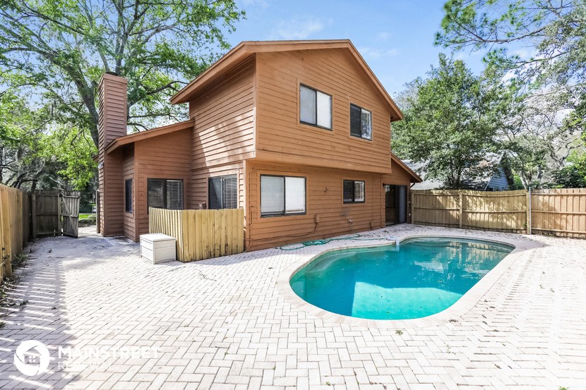 a backyard with a pool and a wooden house