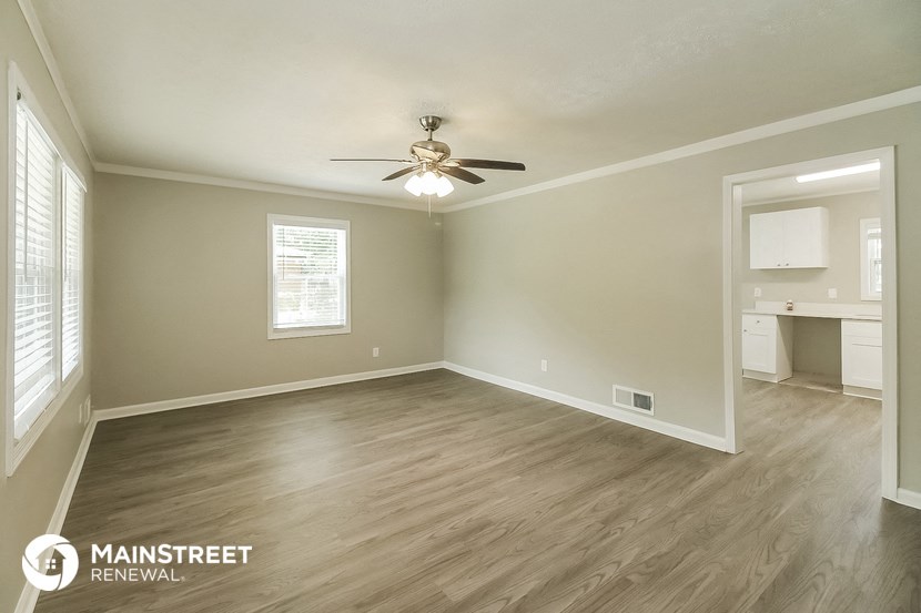 the living room of an empty house with a ceiling fan