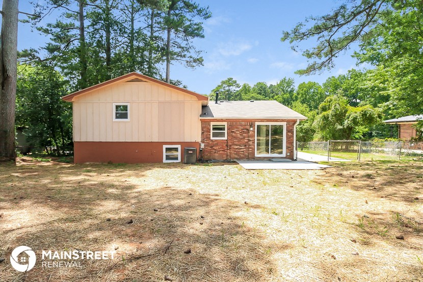 a small brick house with a garage and a yard