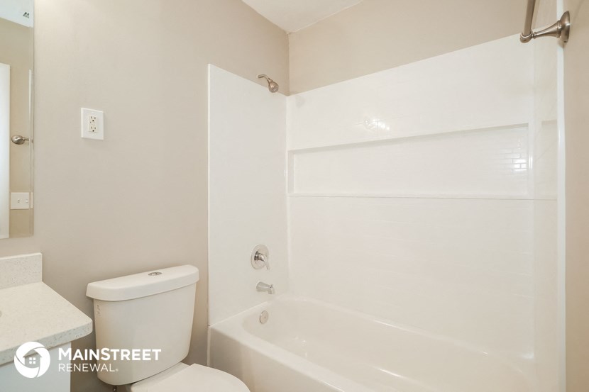 a white bathroom with a tub and a toilet